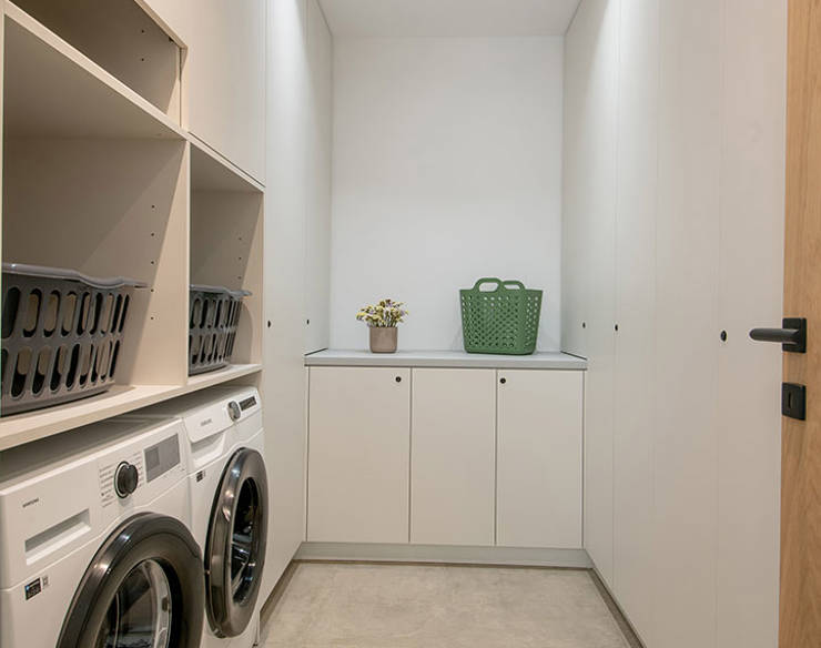 Modern laundry room at Elounda Naxia Villas with washers, built-in cabinets, and minimalist design