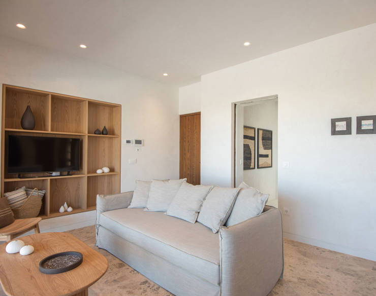 Living area at Elounda Naxia Villas with wooden furniture, large cozy sofa and minimalist decor