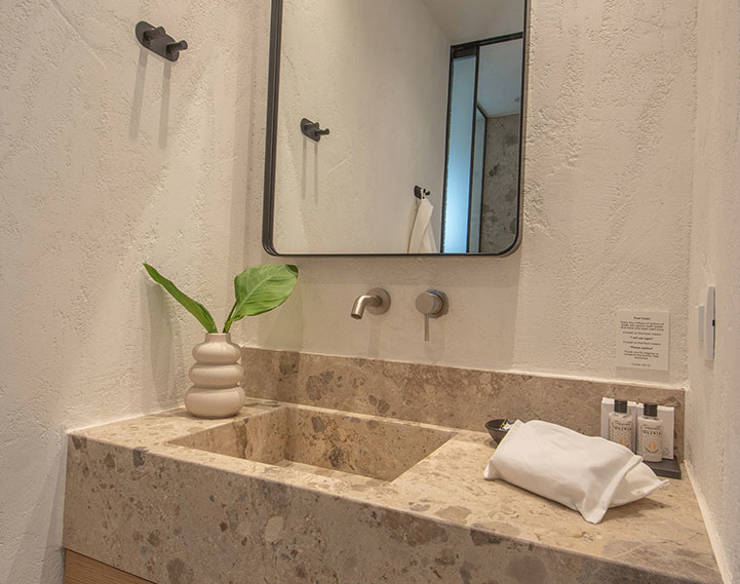 Modern bathroom vanity at Elounda Naxia Villas with stone countertop, large mirror, and minimalist decor